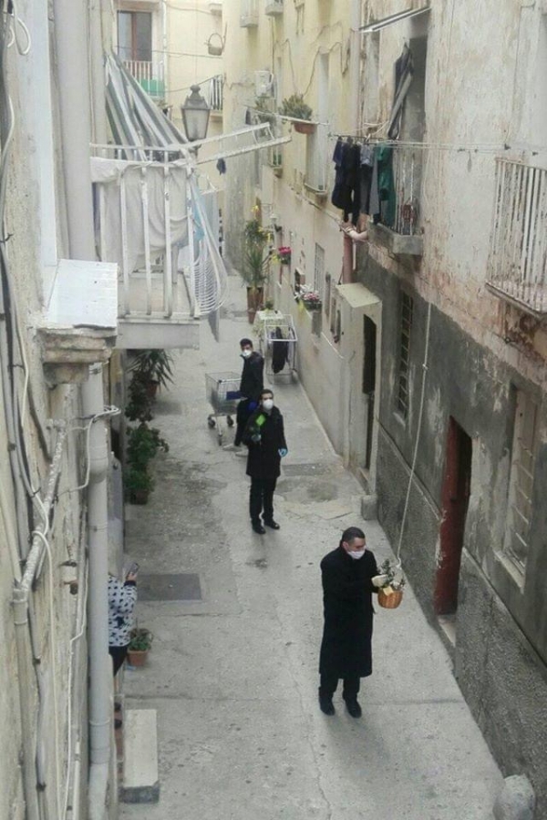 DOMENICA DELLE PALME/ Il parroco della Cattedrale di Taranto distribuisce i ramoscelli d’ulivo mettendoli nei “.panieri” calati dai balconi delle case della Città vecchia